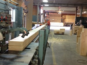 manufaring of custom built log home, logs being cut to exact length, Timberhaven Log Homes, custom built log home, kiln-dried, log cabins