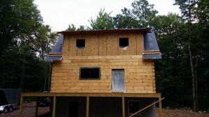 rear of log home home, shed dormer, working toward weather-tight phase, Timberhaven, log homes, log home under construction, custom built log home, laminated, kiln-dried, White Pine