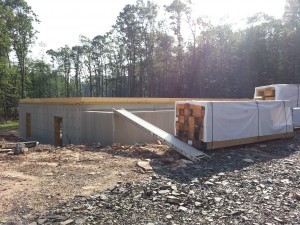 foundation in place subfloor being installed, materials staged on property, post and beam construction, under construction, log homes, log cabins, log cabin kits, Timberhaven, post and beam cabin, post and beam cabin kits, kiln dried, laminated