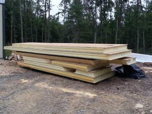 SIPs untarped and staged in preparation for installation, custom post and beam home, post and beam homes, under construction, log homes, log cabin, log cabin kits, Timberhaven Log Homes, laminated, kiln dried, heavy timbers, SIPs