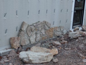 real mountain stone being applied to superior wall, post and beam custom home, under construction, Timberhaven, log homes, log cabins, log cabin kits, contemporary siding, black standing seam metal, stone accents on home, laminated, kiln dried, custom post and beam home