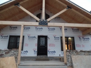 front porch to custom home, post and beam custom home, under construction, Timberhaven, log homes, log cabins, log cabin kits, contemporary siding, black standing seam metal, stone accents on home, laminated, kiln dried, custom post and beam home