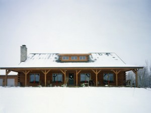 log home in the snow, timberhaven log homes, log homes, log cabin kits, log cabins, Merry Christmas, stone fireplace, fireplace in dining room, natural light, white pine