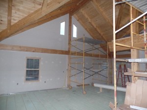 wide open space in kitchen and dining areas, dry wall installation, beam and purlin roof system, post and beam, custom home, log homes, log cabins, log cabin kits, Timberhaven, laminated, kiln dried, under construction, PA log home producer