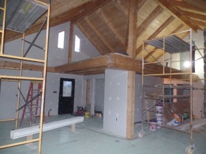 wide open space in main living area and loft, beam and purlin roof system, post and beam, custom home, log homes, log cabins, log cabin kits, Timberhaven, laminated, kiln dried, under construction, PA log home producer, dry wall installation