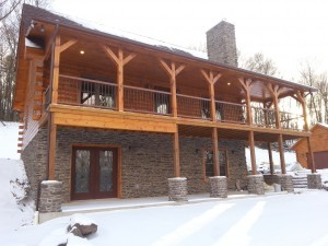 exterior of custom log home with walk-out basement and stone pillars, Timberhaven Log Homes, Valley View, floor plan ideas, complete customization, laminated logs, engineered logs, kiln dried logs, design services, Pennsylvania, log homes, log cabins, log cabin kits, log cabin homes, log home packages