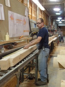 Randy double checking the length of a laminated log cut, employee spotlight, Randy Beachel, Timberhaven Log Homes, log homes, log cabin homes, log cabins, post and beam homes, timberframe homes, timber frame homes, laminated logs, engineered logs, floor plan designs, kiln dried logs