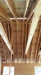 underside of roof showing rafters and ridge beam, roof being constructed on a log home, beautiful bedroom in log home, Timberhaven Log Homes, log homes, log cabin homes, log cabins, post and beam homes, timberframe homes, timber frame homes, laminated logs, engineered logs, floor plan designs, kiln dried logs, Flury Builders, Joe Walsh, Timberhaven local reps, log homes in Massachusetts, log homes in Rhode Island, MA, RI, log home builders, 2x12 rafter roof system