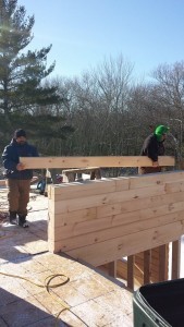 two men stacking White Pine laminated logs, Rhode Island log home, Timberhaven Log Homes, log homes, log cabin homes, log cabins, post and beam homes, timberframe homes, timber frame homes, laminated logs, engineered logs, floor plan designs, kiln dried logs, Flury Builders, Joe Walsh, Timberhaven local reps, log homes in Massachusetts, log homes in Rhode Island, MA, RI, log home builders