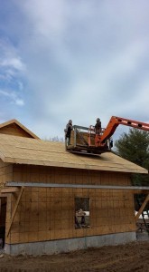 builders using lift to finish OSB sheathing application to garage roof, two-car garage, Timberhaven Log Homes, log homes, log cabin homes, log cabins, post and beam homes, timberframe homes, timber frame homes, laminated logs, engineered logs, floor plan designs, kiln dried logs, Flury Builders, Joe Walsh, Timberhaven local reps, log homes in Massachusetts, log homes in Rhode Island, MA, RI, log home builders