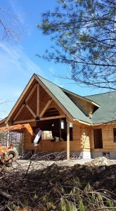 gable end of log home under construction with new shingles, Tamko, log home roof, Timberhaven Log Homes, log homes, log cabin homes, log cabins, post and beam homes, timberframe homes, timber frame homes, laminated logs, engineered logs, floor plan designs, kiln dried logs, Flury Builders, Joe Walsh, Timberhaven local reps, log homes in Massachusetts, log homes in Rhode Island, MA, RI, log home builders