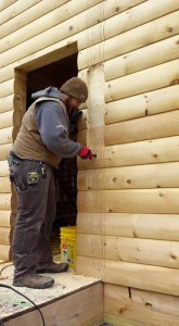 builder chiseling out log way for post, solid log breezeway, Log Homes, log homes, log cabin homes, log cabins, post and beam homes, timberframe homes, timber frame homes, laminated logs, engineered logs, floor plan designs, kiln dried logs, Flury Builders, Joe Walsh, Timberhaven local reps, log homes in Massachusetts, log homes in Rhode Island, MA, RI, log home builders, solid log breezeway