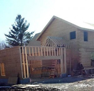 conventionally built garage without a roof and log home, two-car garage, Timberhaven Log Homes, log homes, log cabin homes, log cabins, post and beam homes, timberframe homes, timber frame homes, laminated logs, engineered logs, floor plan designs, kiln dried logs, Flury Builders, Joe Walsh, Timberhaven local reps, log homes in Massachusetts, log homes in Rhode Island, MA, RI, log home builders