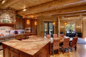 log home open kitchen and dining area with stone fireplace and granite countertops and massive beams, log home flooring, Timberhaven Log Homes, log homes, log cabin homes, log cabins, post and beam homes, timberframe homes, timber frame homes, laminated logs, engineered logs, floor plan designs, kiln dried logs, Flury Builders, Joe Walsh, Timberhaven local reps, log homes in Massachusetts, log homes in Rhode Island, MA, RI, log home builders