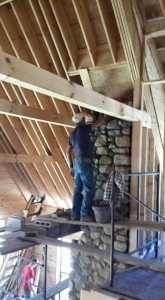 builder placing stone up full masonry fireplace, full masonry fireplace, Timberhaven Log Homes, log homes, log cabin homes, log cabins, post and beam homes, timberframe homes, timber frame homes, laminated logs, engineered logs, floor plan designs, kiln dried logs, Flury Builders, Joe Walsh, Timberhaven local reps, log homes in Massachusetts, log homes in Rhode Island, MA, RI, log home builders