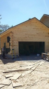 two car garage under construction with log siding being applied, log siding, Timberhaven Log Homes, log homes, log cabin homes, log cabins, post and beam homes, timberframe homes, timber frame homes, laminated logs, engineered logs, floor plan designs, kiln dried logs, Flury Builders, Joe Walsh, Timberhaven local reps, log homes in Massachusetts, log homes in Rhode Island, MA, RI, log home builders