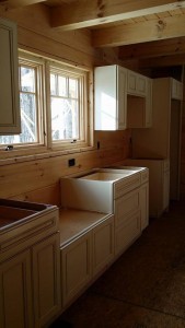 white cabinets partiually installed in log home, Log home kitchen, Timberhaven Log Homes, log homes, log cabin homes, log cabins, post and beam homes, timberframe homes, timber frame homes, laminated logs, engineered logs, floor plan designs, kiln dried logs, Timberhaven local reps, log homes in PA, log home builders