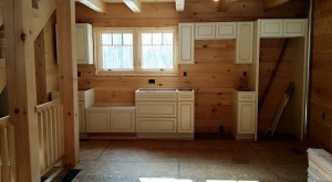 white kitchen cabinets installed in log home, Log home kitchen, Timberhaven Log Homes, log homes, log cabin homes, log cabins, post and beam homes, timberframe homes, timber frame homes, laminated logs, engineered logs, floor plan designs, kiln dried logs, Timberhaven local reps, log homes in PA, log home builders