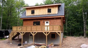 rear of log home half treated with Q8 Log Oil, Light Pecan, Protect your log home investment, treatment for log home, preservative maintenance, Log home kitchens, Timberhaven Log Homes, log homes, log cabin homes, log cabins, post and beam homes, timberframe homes, timber frame homes, laminated logs, engineered logs, floor plan designs, kiln dried logs, Timberhaven local reps, log homes in PA, log home builders