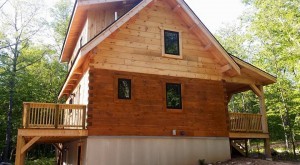 log wall half treated with preservative, Light Pecan, Protect your log home investment, treatment for log home, preservative maintenance, Log home kitchens, Timberhaven Log Homes, log homes, log cabin homes, log cabins, post and beam homes, timberframe homes, timber frame homes, laminated logs, engineered logs, floor plan designs, kiln dried logs, Timberhaven local reps, log homes in PA, log home builders