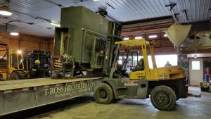 laminator being lifted onto lowboy with forklift, Big move, Timberhaven Log Homes, Timberhaven Log & Timber Homes, log homes, log cabin homes, log cabins, post and beam homes, timberframe homes, timber frame homes, laminated logs, engineered logs, floor plan designs, kiln dried logs, Timberhaven local reps, log homes in PA