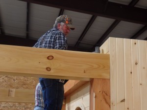 guy placing beam for engineered log display, making great progress, log homes, log cabin homes, log cabins, post and beam homes, timberframe homes, timber frame homes, laminated logs, engineered logs, floor plan designs, kiln dried logs, Timberhaven local reps, log homes in Pennsylvania, log homes in PA, Timberhaven Log Homes, Timberhaven Log & Timber Homes