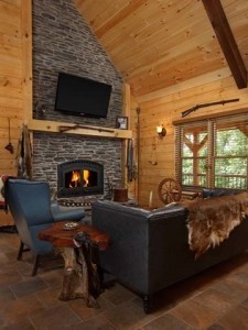 living room with stone fireplace, flat screen TV on fireplace mantel, cabin living, log homes, log cabin homes, log cabins, post and beam homes, timberframe homes, timber frame homes, laminated logs, engineered logs, floor plan designs, kiln dried logs, Timberhaven local reps, log homes in Pennsylvania, log homes in PA, Timberhaven Log Homes, Timberhaven Log & Timber Homes