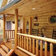 Log Home Porch with Rustic Rail Treatment Illustrates the Use of Natural Building Components in Log Home Construction