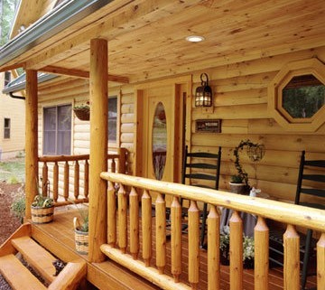 Log Home Porch with Rustic Rail Treatment Illustrates the Use of Natural Building Components in Log Home Construction