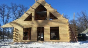 precutting process, log home under construction in the snow, solid log gable ends, timberhaven, log homes, log cabin homes, log cabins, timber frame homes, timber homes