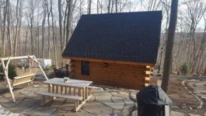 logo cabin with log outdoor furniture, small log cabin in the woods, unique log cabin, log cabin home, log cabins, log homes, timber frame homes, Engineered Logs, Timberhaven Log & Timber Homes