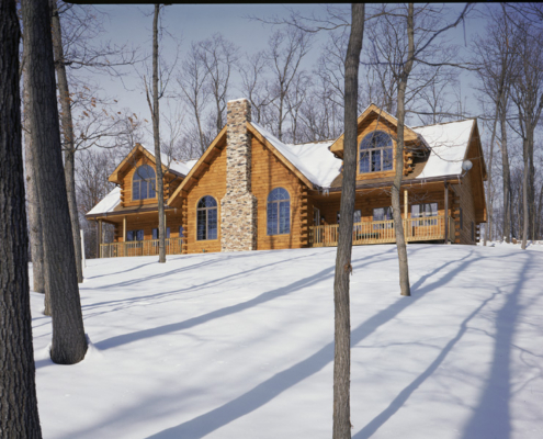 Traditional style log home in the snow.