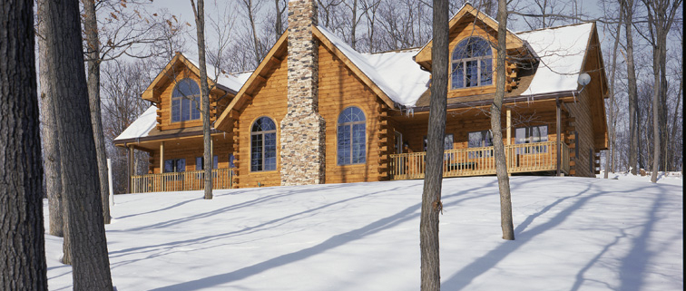 Traditional style log home in the snow.