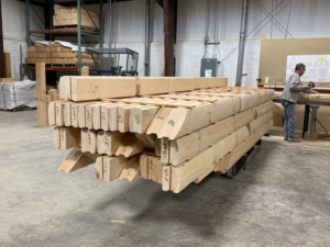 stacked logs in manufacturing facility, New Model Log Home Delivery, log home delivery, delivery day, log homes, Timberhaven, local reps, model home in TN