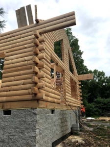 mortise and tenon corners on logs, log walls, new model log home under construction