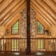 Round rafters in log home loft.