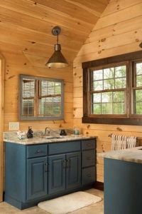 log home bathroomw with blue cabinets, log home with stone in the woods, custom log home, Timberhaven, engineered logs, log homes in PA, kiln dried, custom home package