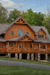 log home with stone in the woods, mountain log home, custom log home, Timberhaven, engineered logs, log homes in PA, kiln dried, custom home package