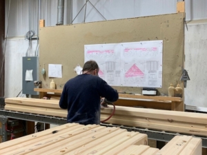 guy sanding logs, logs, white pine, kiln dried, engineered, Timberhaven, Alaskan bound log home