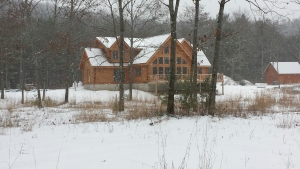 Cape Cod log home in the wood covered with snow, Timberhaven, Chesapeake log home design