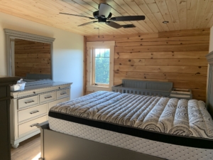 Timber Frame Model Home Under Construction, Bedroom with Log Wall, Timberhaven